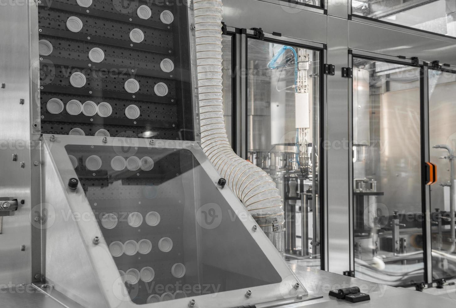 conveyor with lids for bottles at the milk factory. equipment at the dairy plant photo