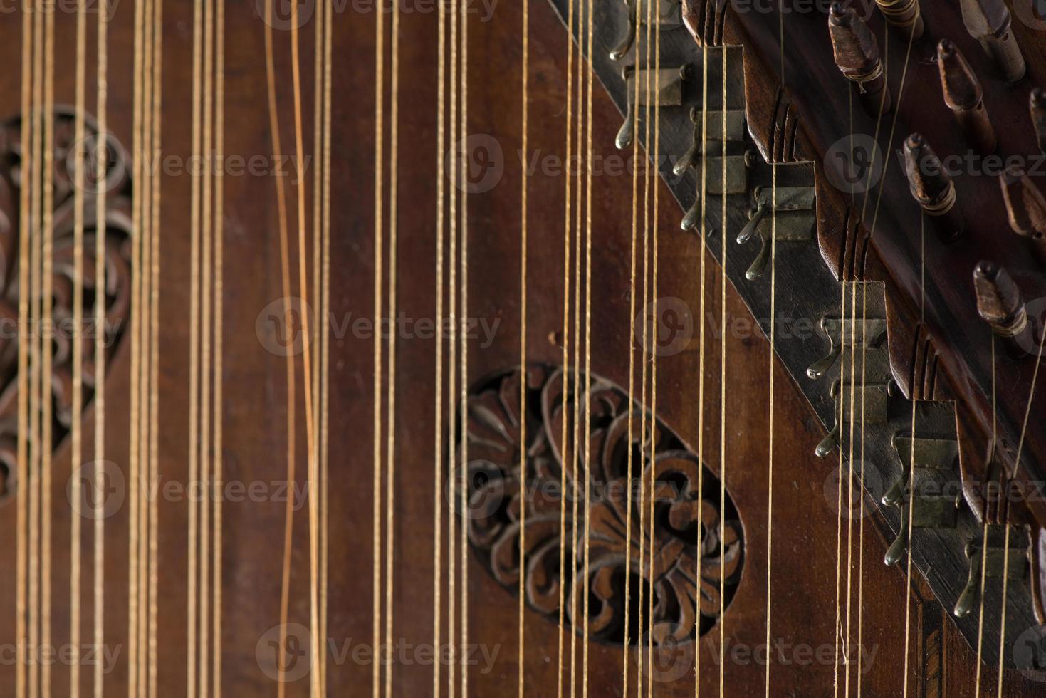 ancient Asian stringed musical instrument on black background with backlight. the similarity of the harp and psaltery. closeup photo