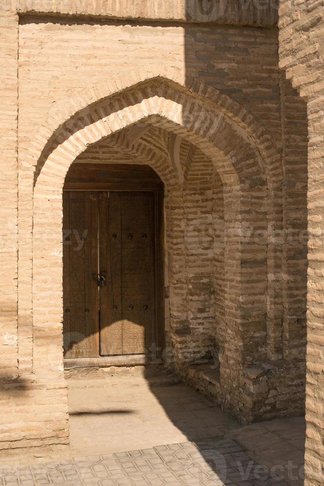 Wooden door with ancient traditional Asian ornamentation and mosaics. the details of the architecture of medieval Central Asia photo