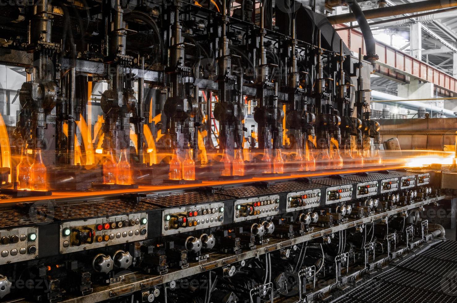 on the conveyor glass bottles are pasteurized with fire. factory for the production of glass bottles and beverage photo