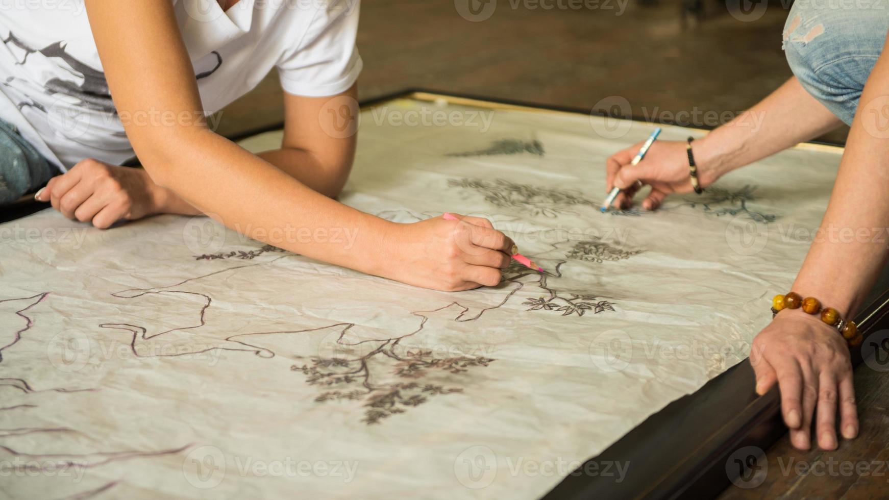 two girls painters draw a sketch through tracing paper, close-up photo