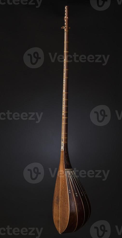 ancient Asian stringed musical instrument on black background with backlight photo