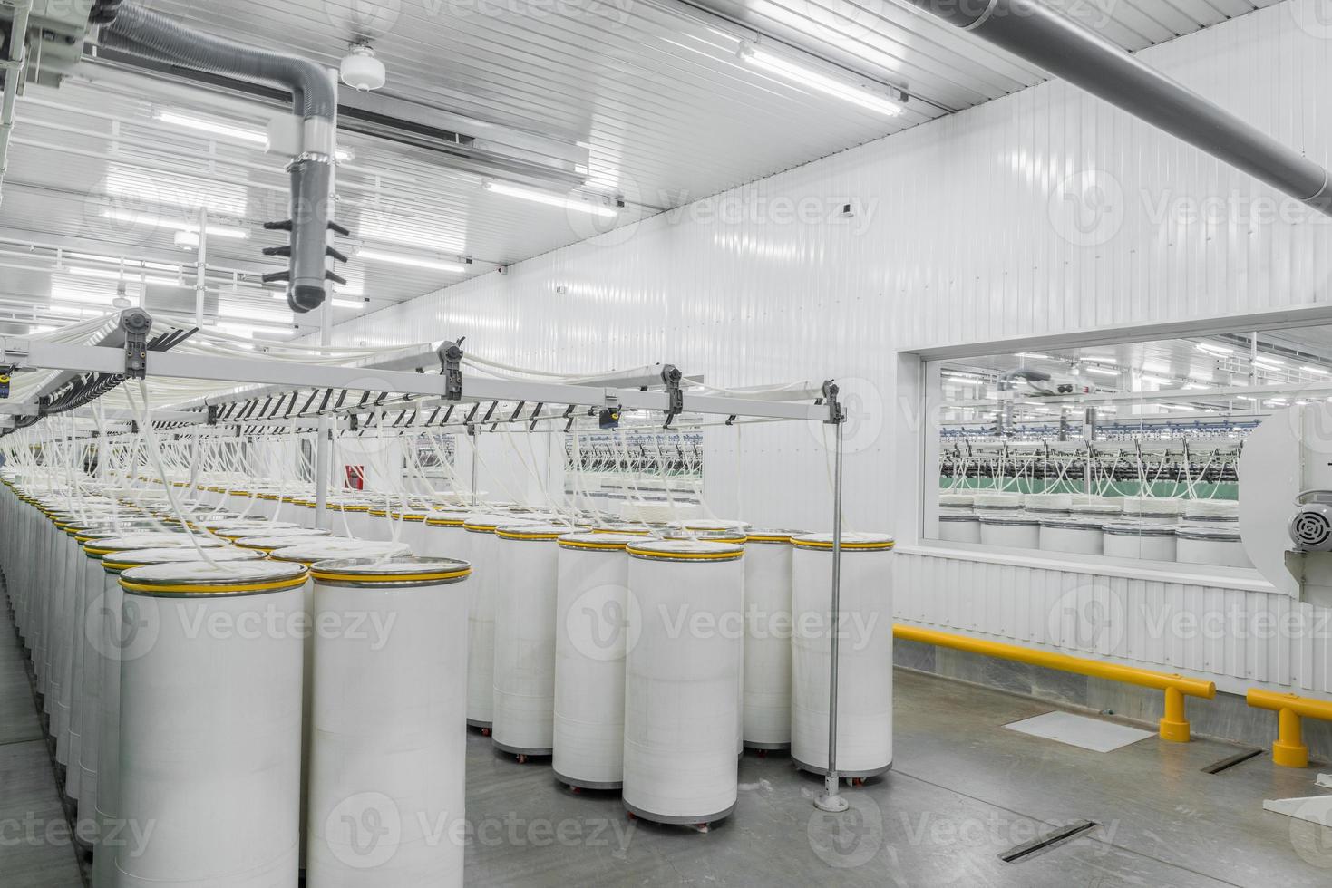 Maquinaria y equipo en el taller para la producción de hilo. interior de la fábrica textil industrial foto