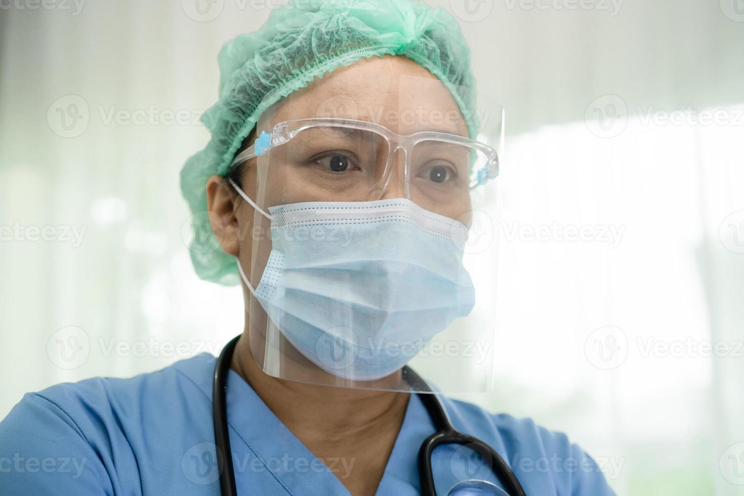 Asian doctor wearing face shield and PPE suit new normal to check patient protect safety infection Covid 19 Coronavirus outbreak at quarantine nursing hospital ward. photo