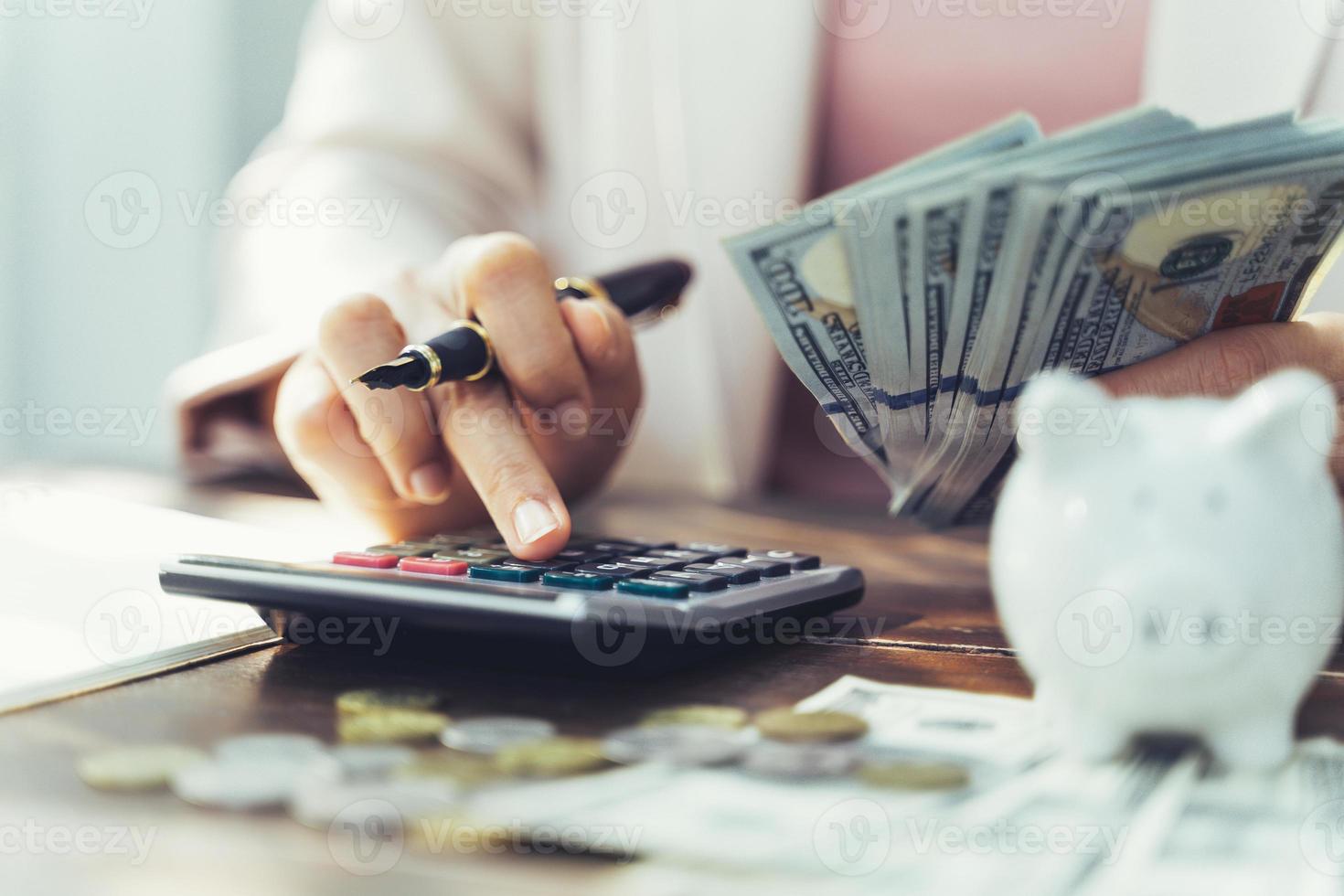 close up of business woman with calculator counting money. saving money and financial concept photo