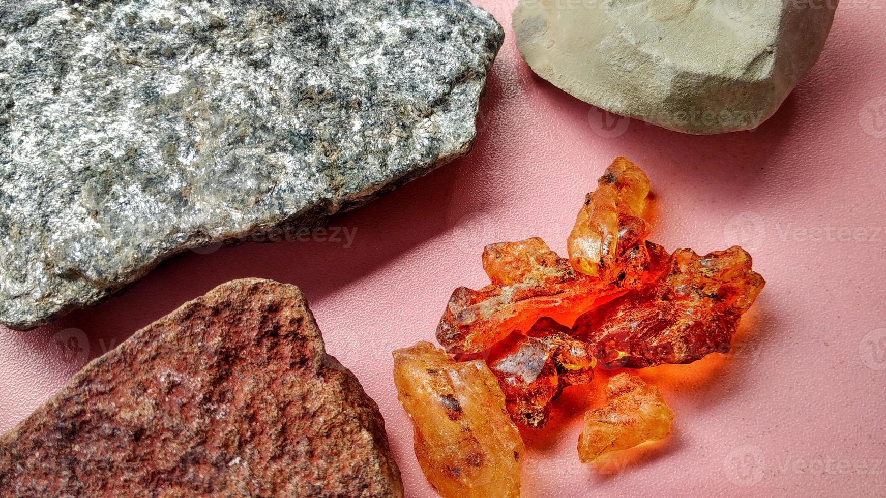 Resin sap is a natural sap from the Agathis borneensis tree, yellow light from central java, Indonesia. Isolated with scistmica, napal and chert, marl from geological collection rock, pink background. photo