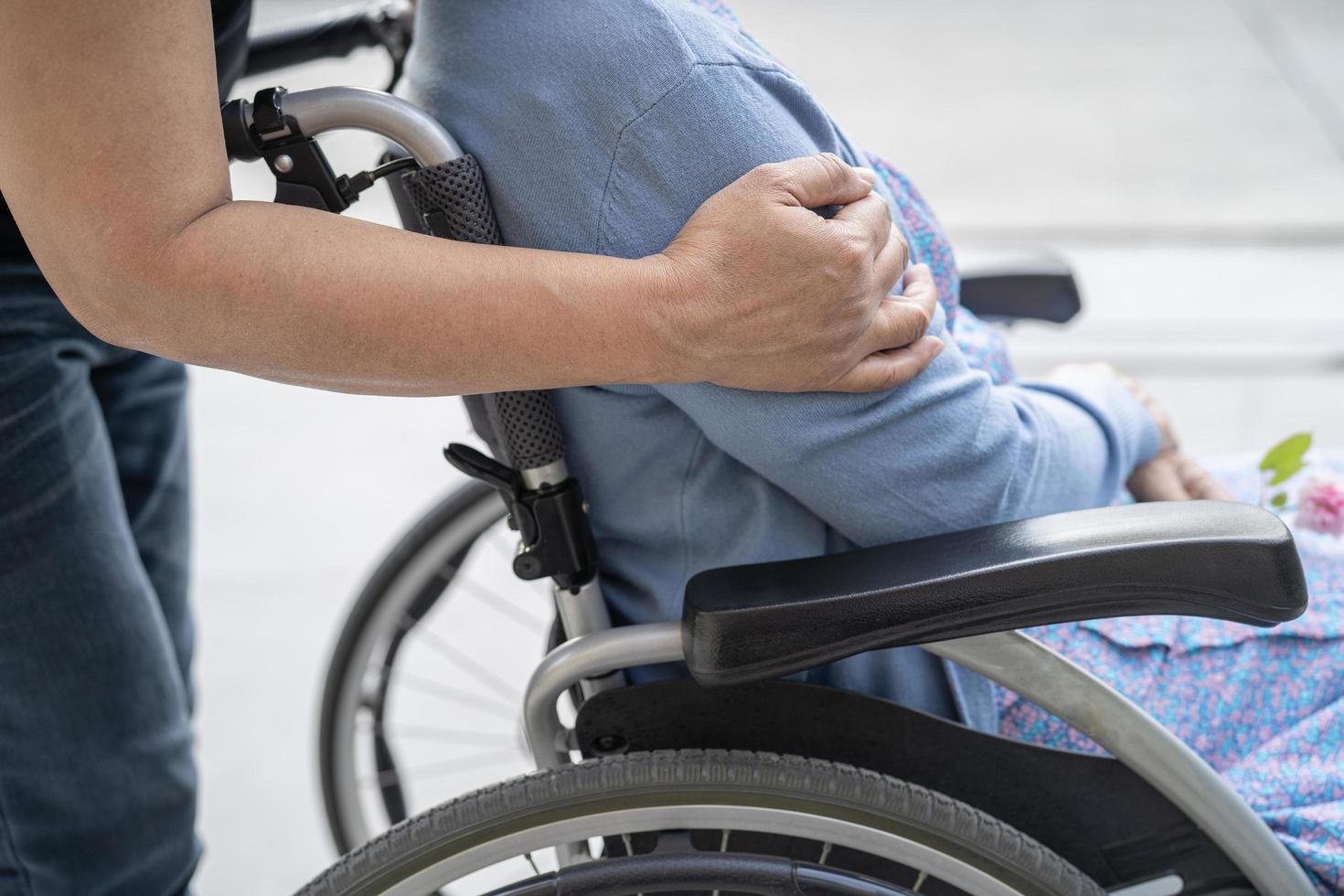 Caregiver help and care Asian senior or elderly old lady woman patient sitting on wheelchair at nursing hospital ward, healthy strong medical concept photo