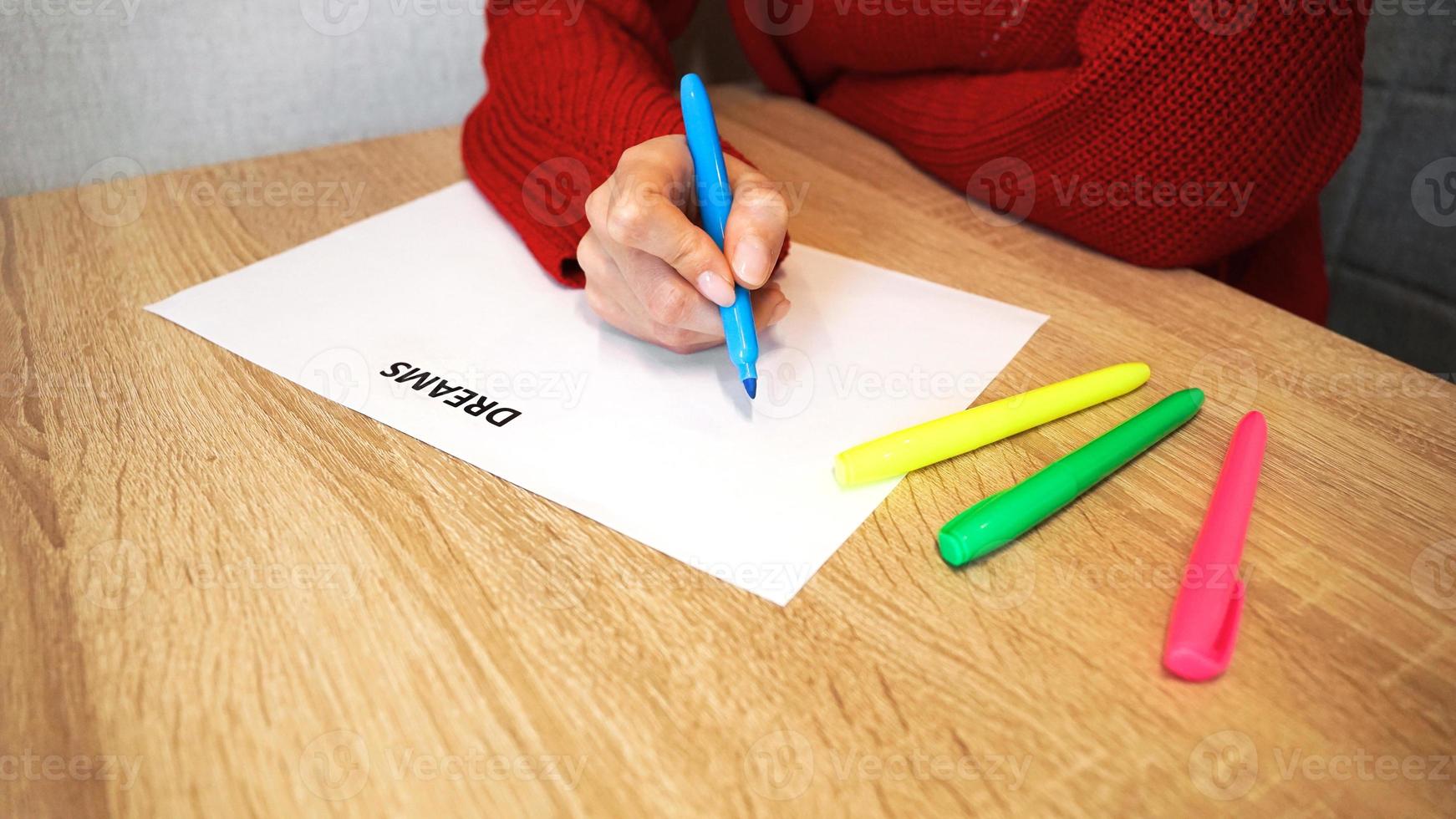 mujer escribiendo su lista de sueños con marcadores de colores foto