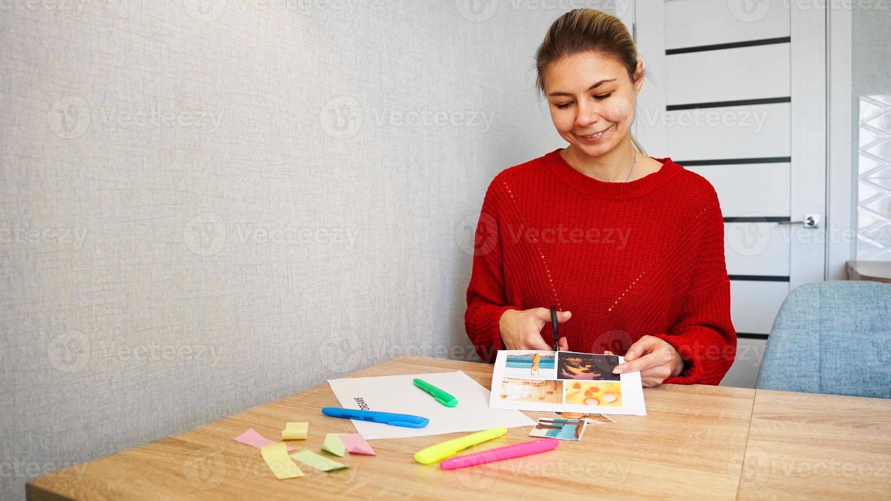 Young woman creating her Feng Shui wish map using scissors. Dreams and wishes. photo