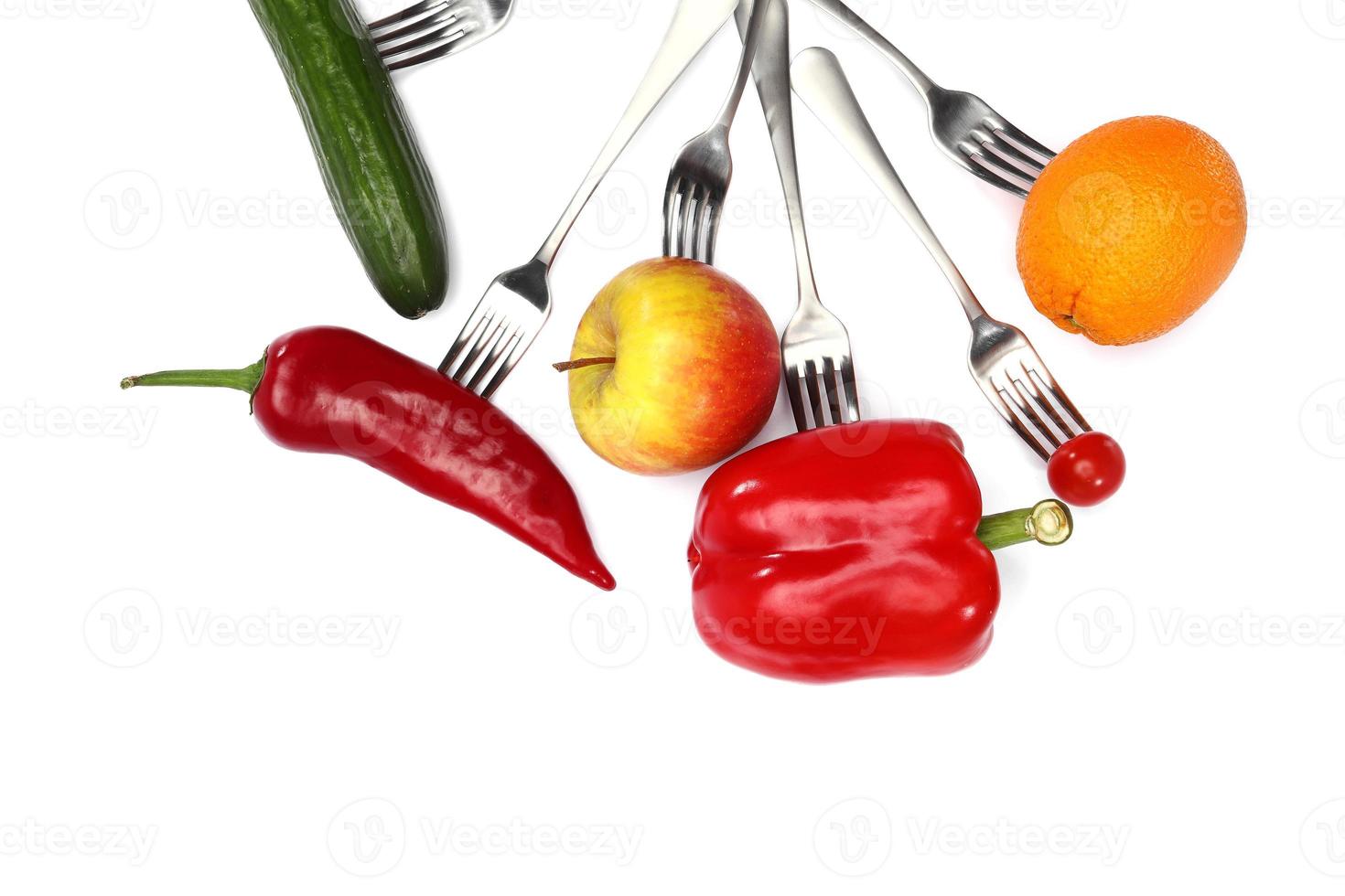 tomate cherry fresco, pimiento rojo, pepino, manzana y frutas naranjas en tenedores sobre fondo blanco. alimentación saludable y comida vegetariana, concepto de cocina. foto
