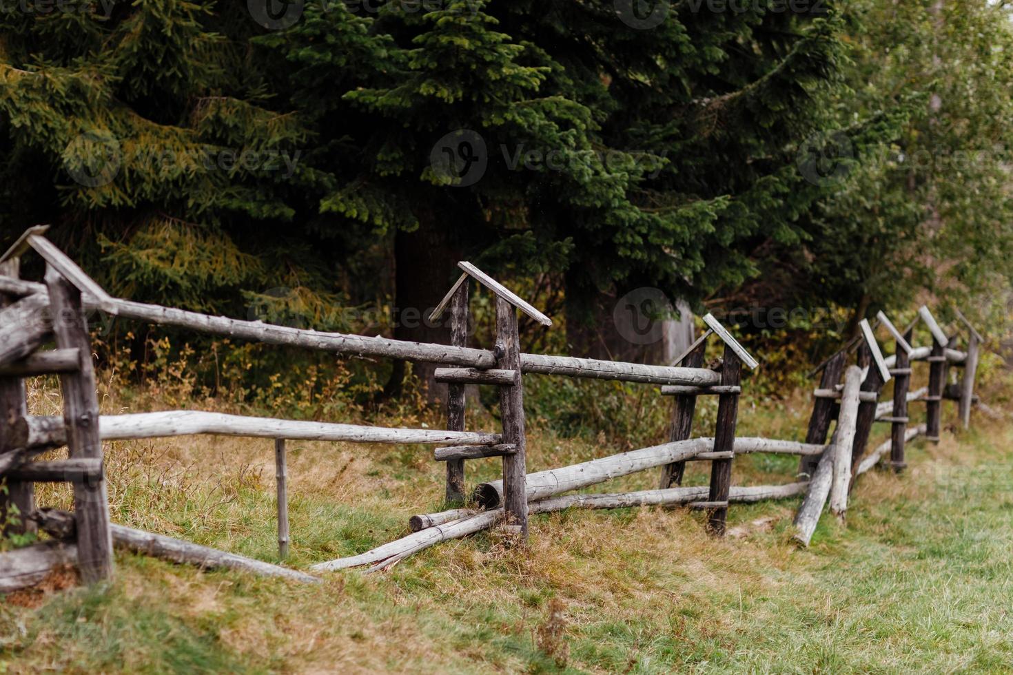 old wooden rural fence in the mountains of a beautiful autumn day photo