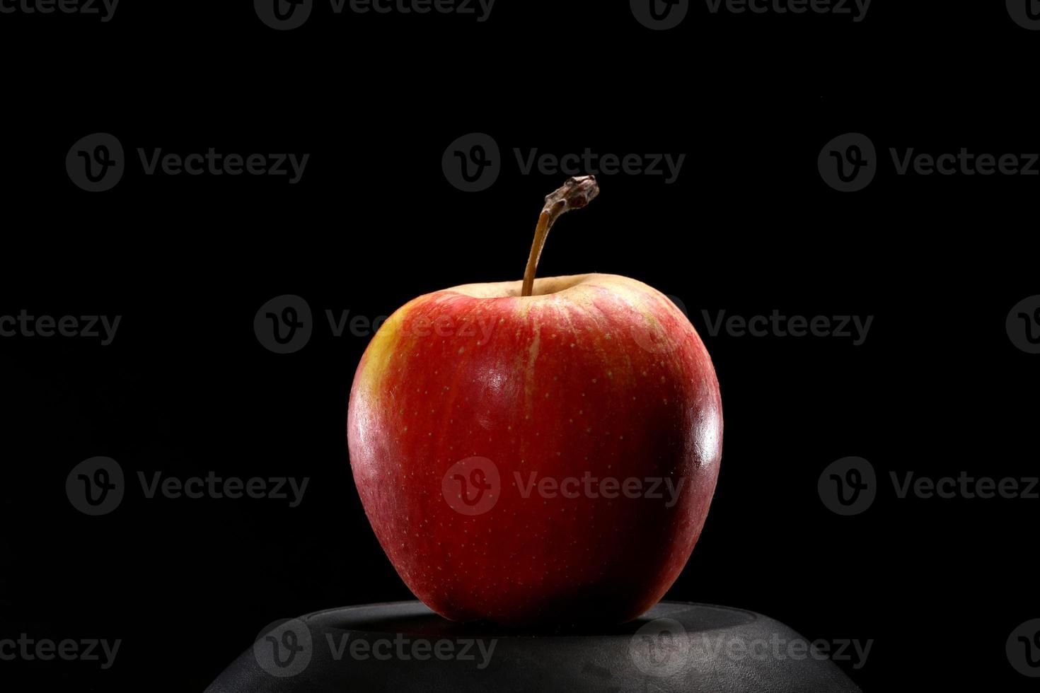 Close up of red organic fresh apple on black background. Healthy food concept. photo