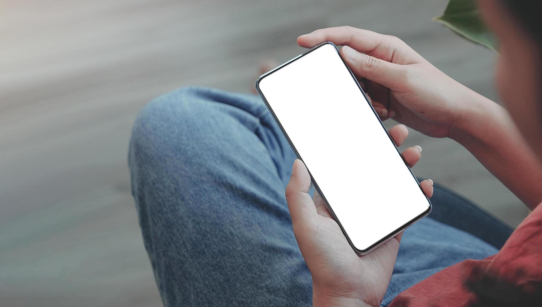 Top view Woman sitting and holding blank screen mock up mobile phone photo