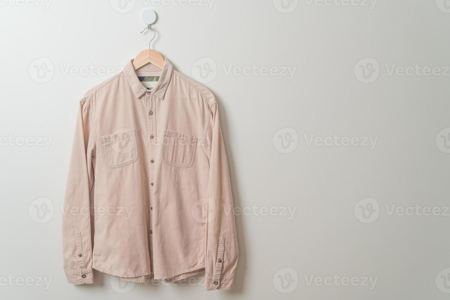 hanging shirt with wood hanger on wall photo