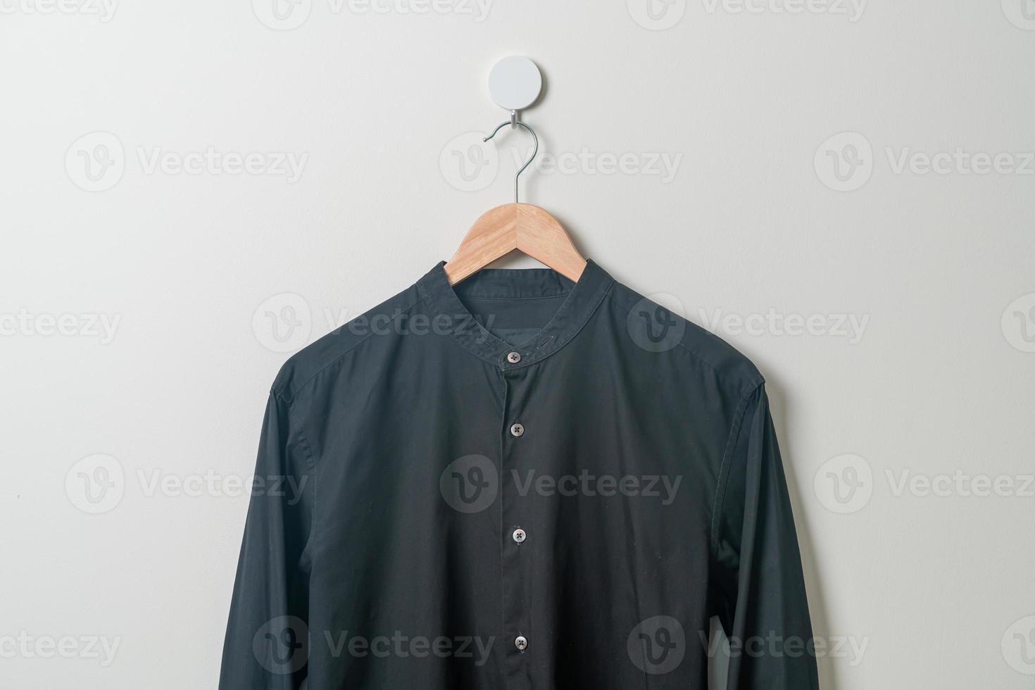 camisa colgante con colgador de madera en la pared foto