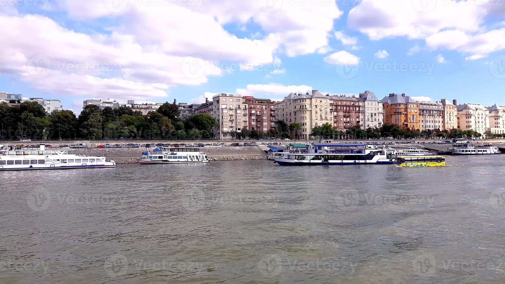 Comfortable yellow bus Tour floating on river Danube. Amphibian bus floating on the river towards the cityscape of Budapest, Hungary. photo