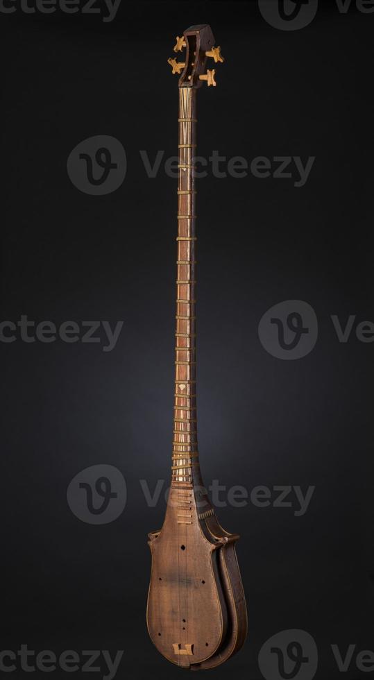 ancient Asian stringed musical instrument on black background with backlight photo