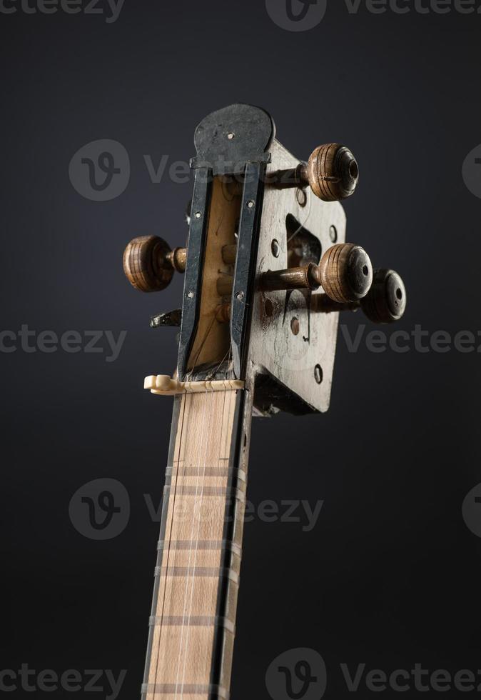 ancient Asian stringed musical instrument on black background with backlight. tuning peg photo