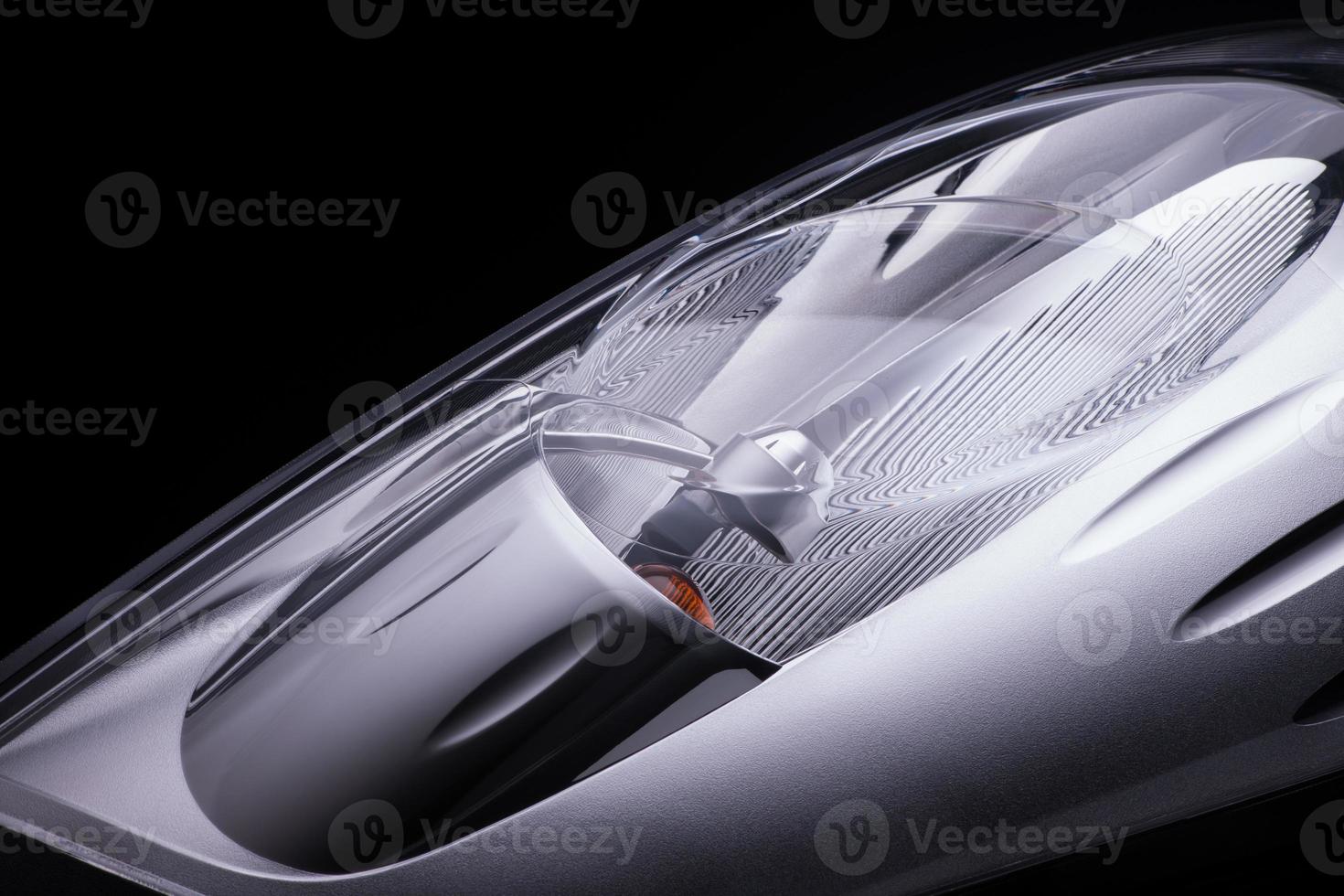 closeup of a car headlight on a black background. trimmed car headlight photo