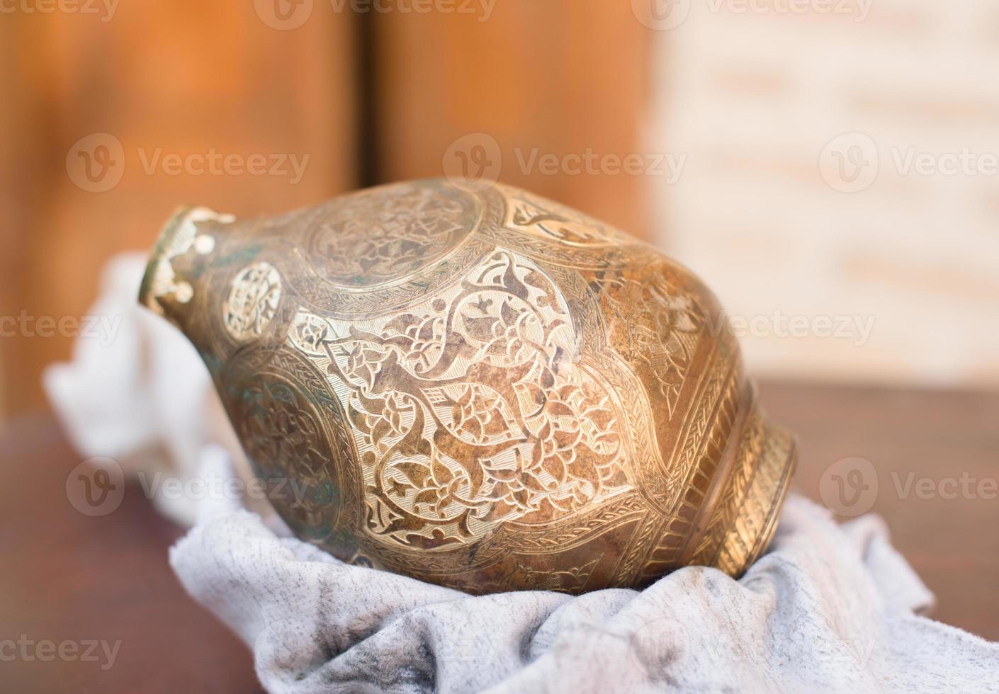 copper jug with Arabic ornament and engraving. manual copper minting photo