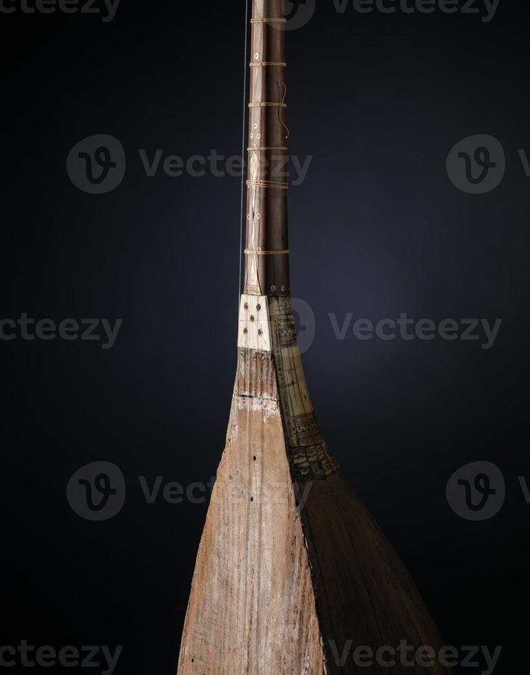 part ancient Asian stringed musical instrument on black background with backlight photo