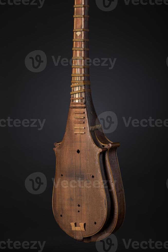 part ancient Asian stringed musical instrument on black background with backlight photo