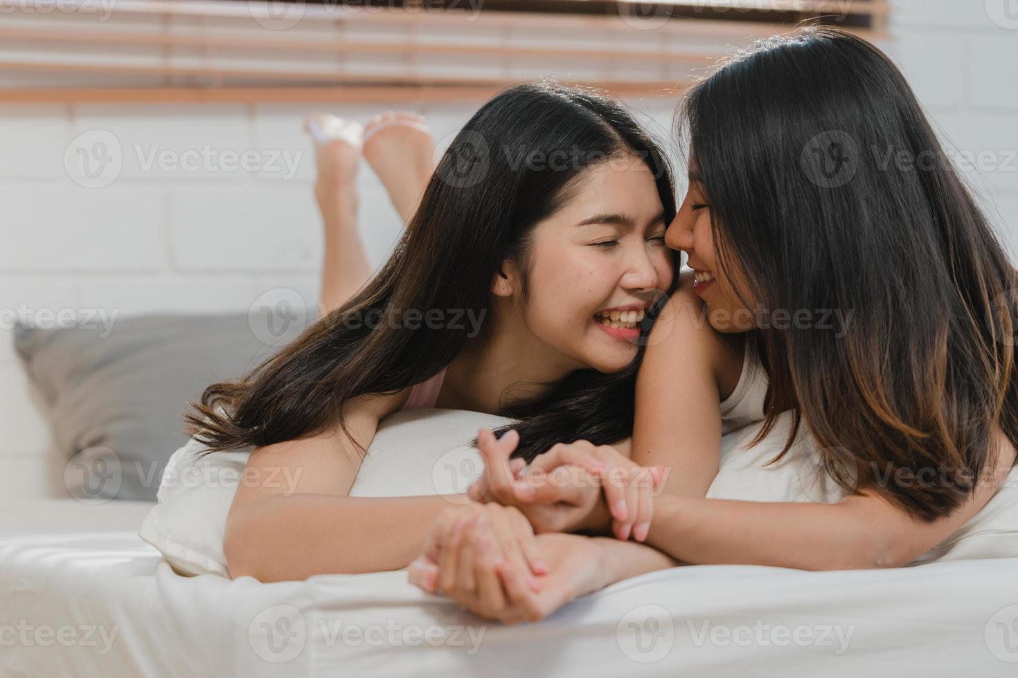 Asian Lesbian lgbtq women couple kiss and hug on bed at home. Young Asia lover female happy relax rest together spend romantic time after wake up in bedroom at home in the morning concept. photo