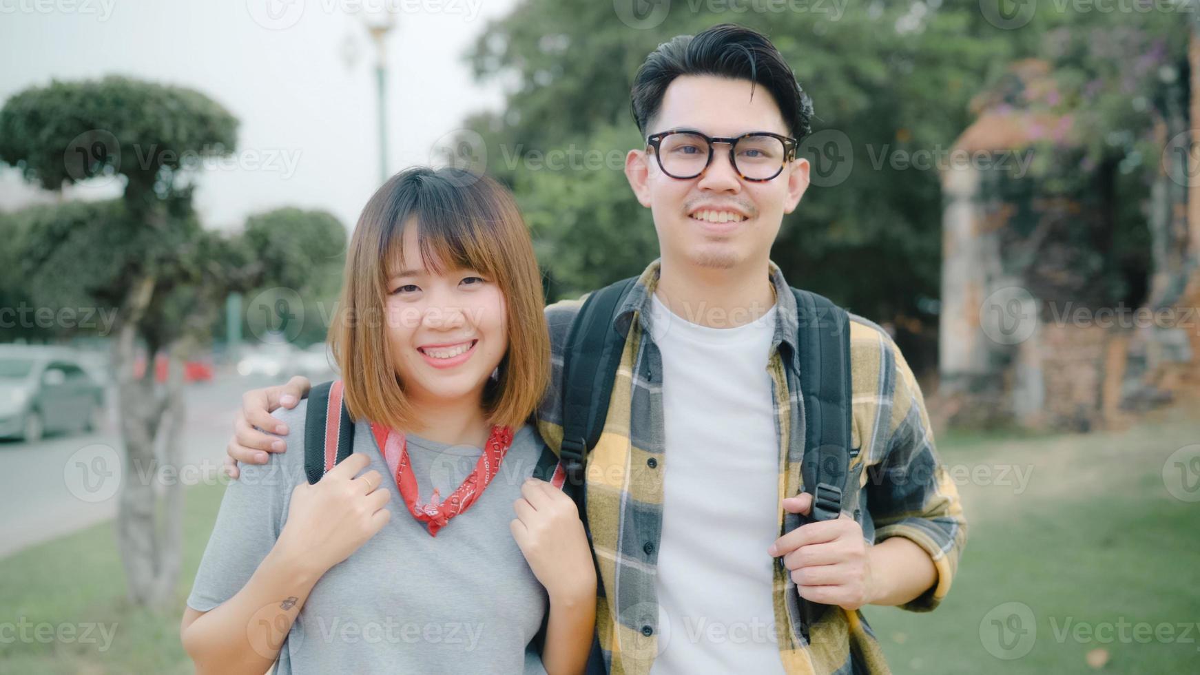 Traveler Asian couple feeling happy smiling to camera holiday trip at Thailand, backpacker sweet couple enjoy their journey at amazing landmark in traditional city. Portrait looking at camera. photo