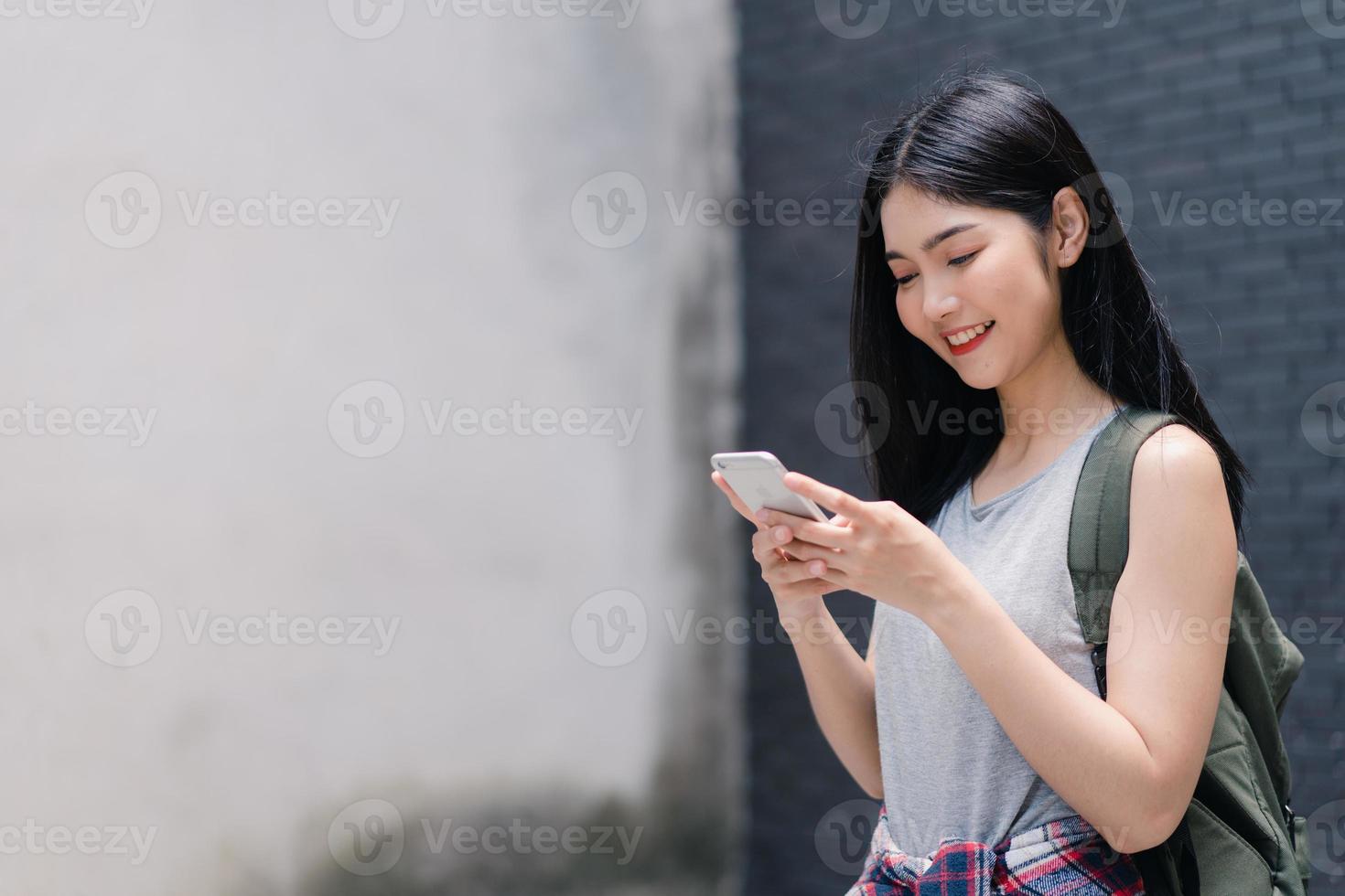 dirección de la mujer asiática del viajero en el mapa de ubicación en beijing, china, mujer mochilera que usa el teléfono móvil mirando en el mapa para encontrar un punto de referencia durante el viaje de vacaciones. las mujeres de estilo de vida viajan en concepto de ciudad foto