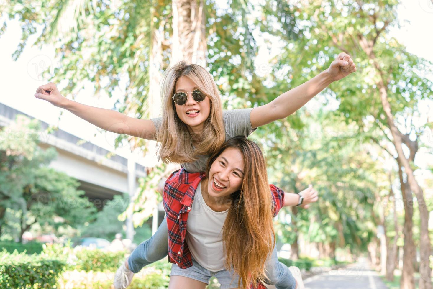 Happy young asian women couple playing to each other while they do city trip in warm sunlight morning weekend. City and nature lifestyle of Young women. Lifestyle in the city activity concept. photo