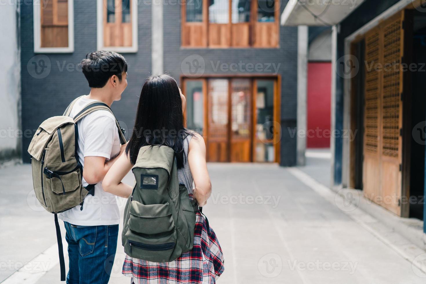 viajero pareja de mochileros asiáticos que se siente feliz viajando en beijing, china, alegre joven pareja adolescente caminando en el barrio chino. estilo de vida mochila viaje turístico vacaciones en concepto de ciudad. foto