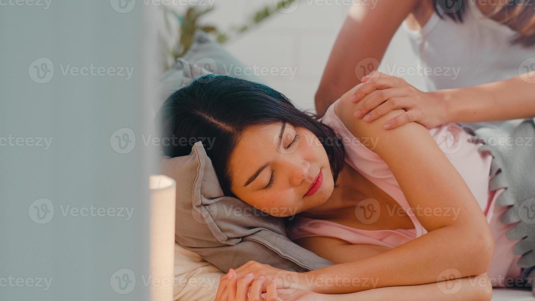 Asian Lesbian lgbtq women couple wake up at home. Young Asia lover female happy relax rest together after sleep all night on bed while lying on bed in bedroom at home in the morning concept. photo