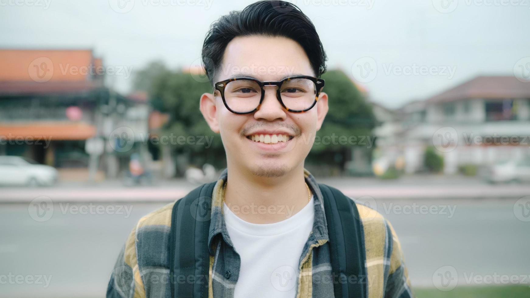 Traveler Asian man feeling happy smiling to camera holiday trip at Ayutthaya, Thailand, backpacker male enjoy his journey at amazing landmark in traditional city. Lifestyle men travel holidays concept photo