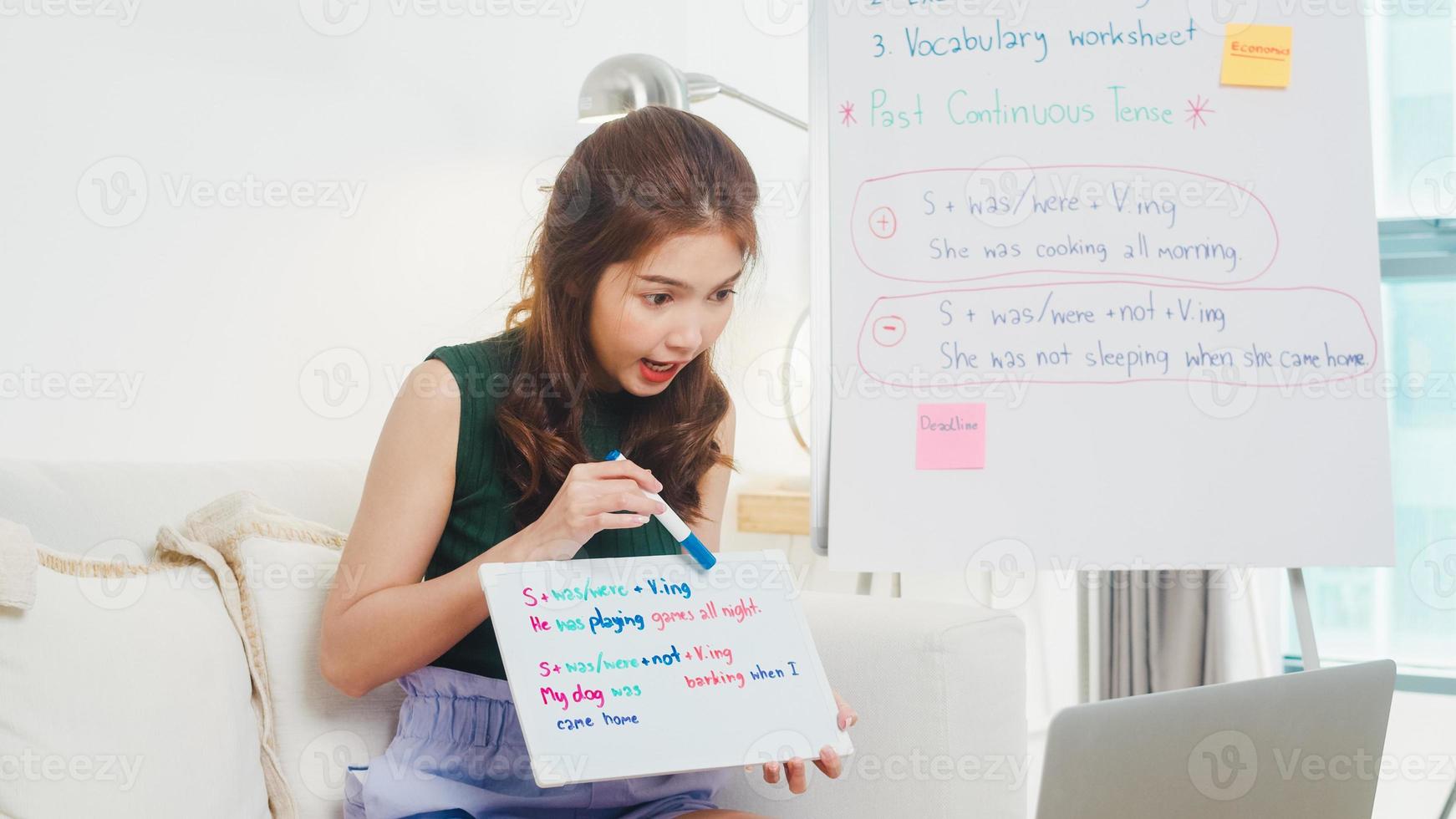 videoconferencia de una joven profesora de inglés de asia llamando a una computadora portátil hablando por cámara web aprendiendo a enseñar en el chat en línea. educación remota, distanciamiento social, cuarentena para la prevención del virus de la corona. foto