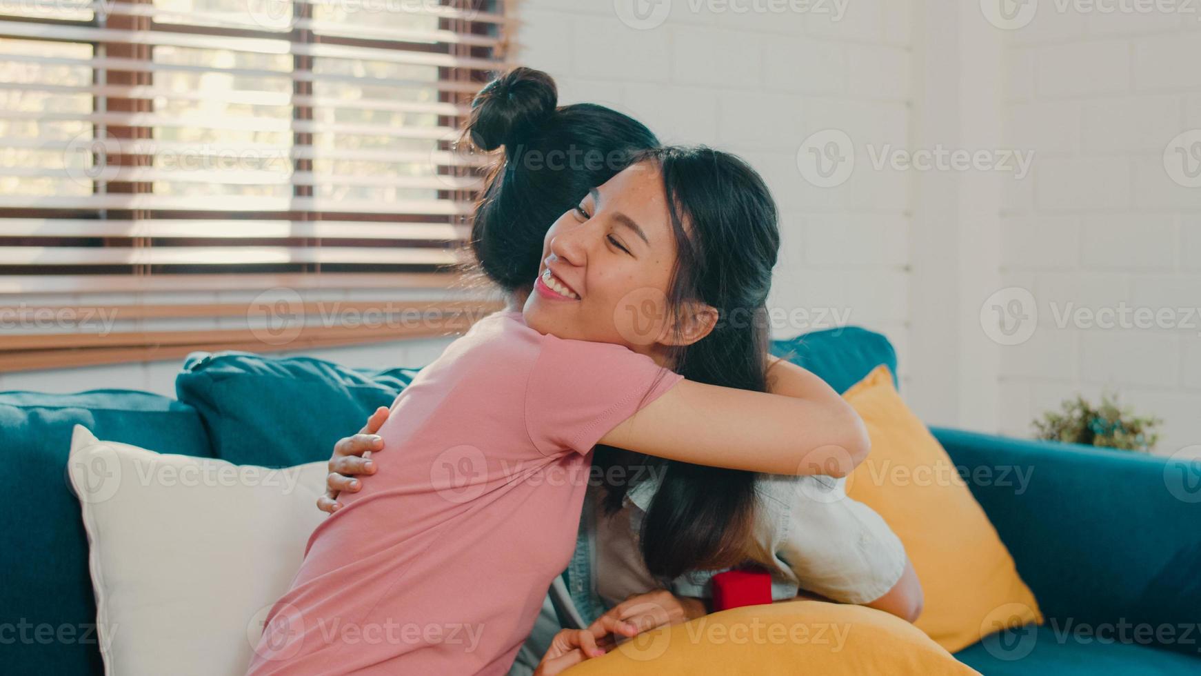 Asian Lesbian lgbtq women couple propose at home, Young Asia lover female happy smiling have romantic time while proposing and marriage surprise wear wedding ring in living room at home concept. photo