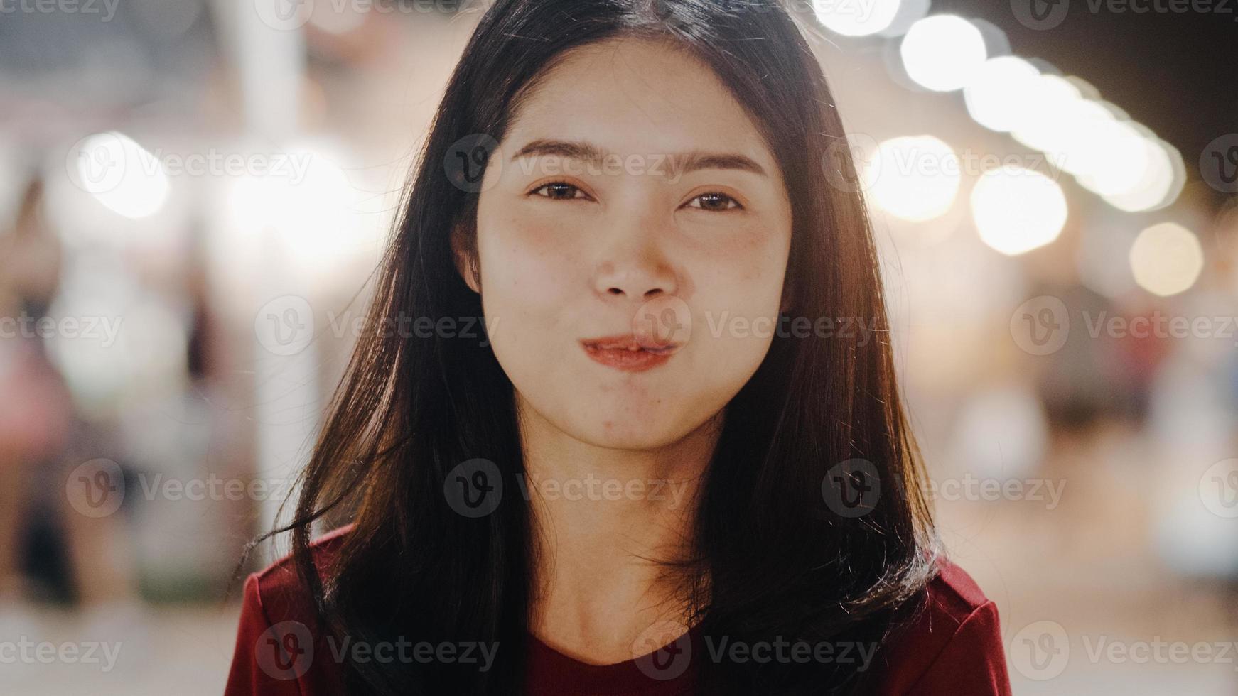 mujer joven asiática viaja en bangkok, tailandia, hermosa mujer que se siente feliz caminando y comiendo pad thai en la calle khao san. las mujeres viajan comen comida callejera en el concepto de tailandia. foto