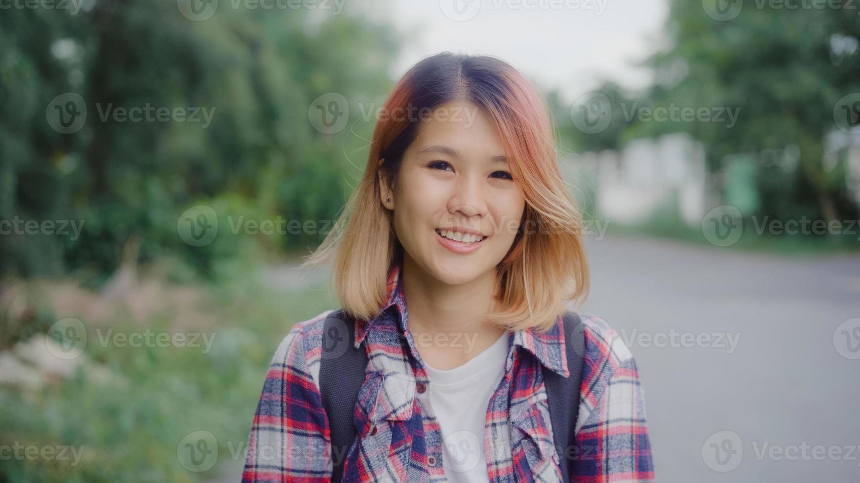 Asian hiker woman trekking in forest. Young happy backpack girl smiling to camera, travel nature and adventure trip, climb mountain lot of tree in spring holidays vacation concept. photo