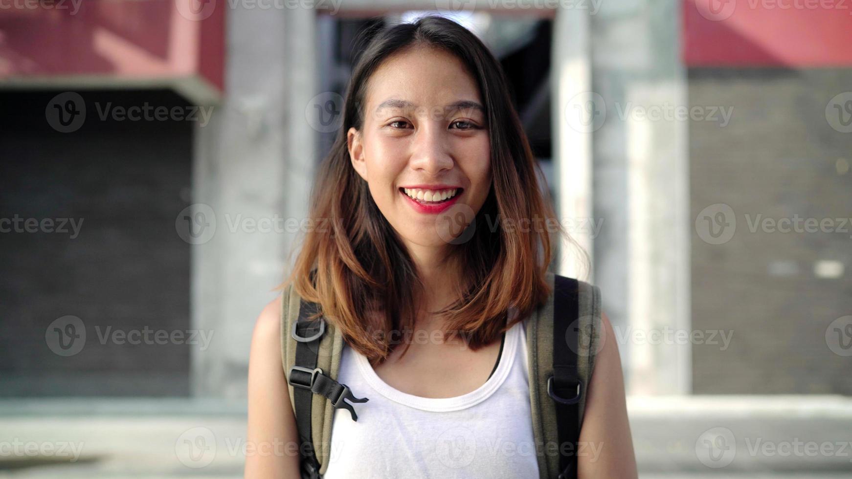 Cheerful beautiful young Asian backpacker woman feeling happy smiling to camera while traveling at Chinatown in Beijing, China. Lifestyle backpack tourist travel holiday concept. photo