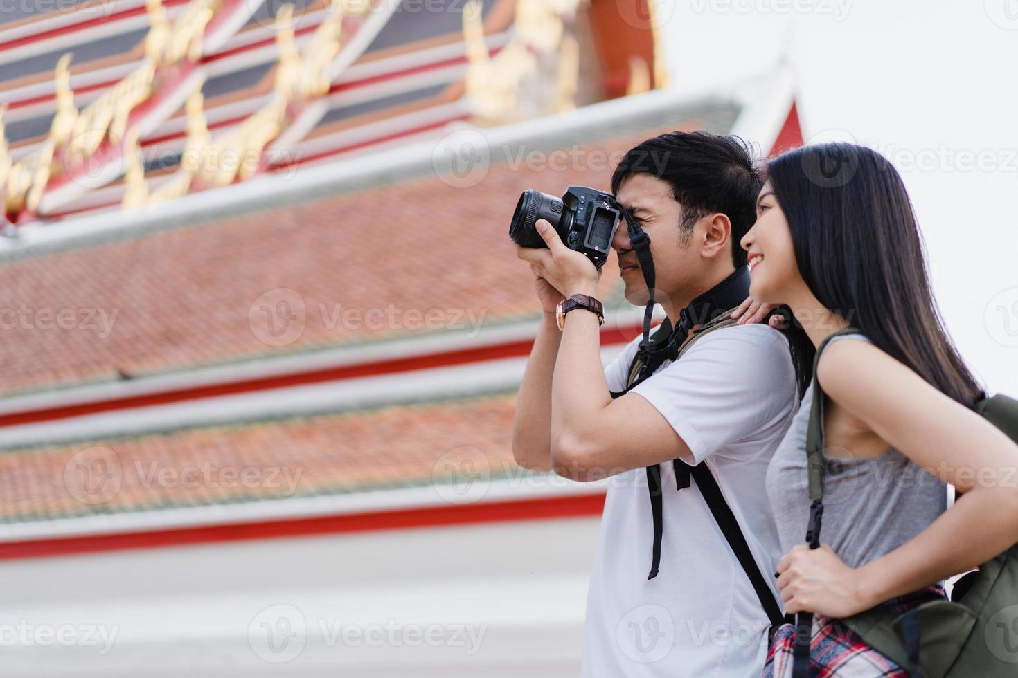 Traveler Asian couple using camera for take a picture while spending holiday trip at Bangkok, Thailand, couple enjoy journey at amazing landmark in city. Lifestyle couple travel in city concept. photo