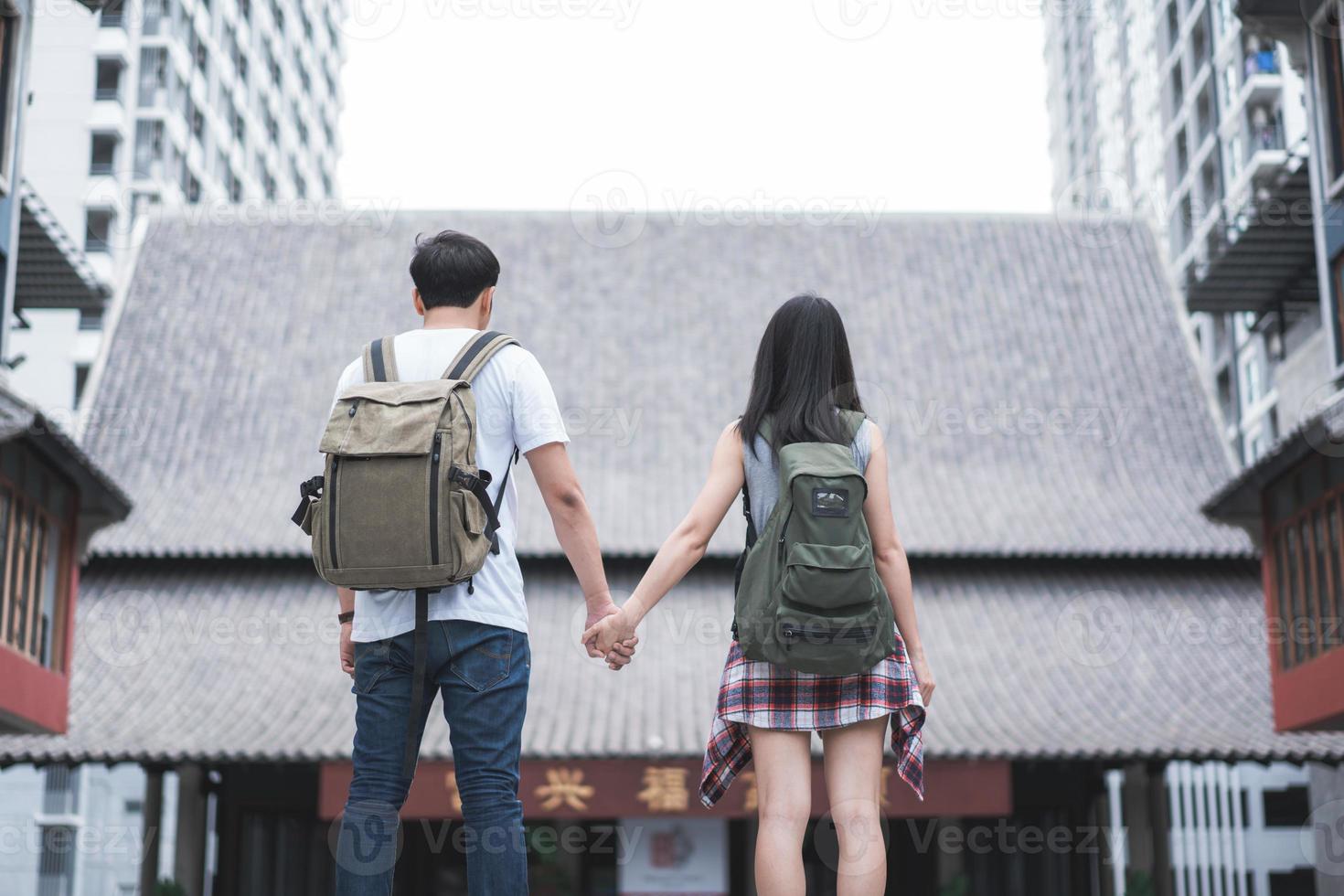 viajero pareja de mochileros asiáticos que se siente feliz viajando en beijing, china, alegre joven pareja adolescente caminando en el barrio chino. estilo de vida mochila viaje turístico vacaciones en concepto de ciudad. foto