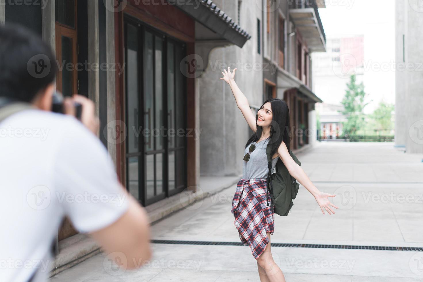 Traveler Asian couple travel in Beijing, China, sweet couple using camera taking photo each other near street while spending holiday trip. Lifestyle couple travel in city concept.