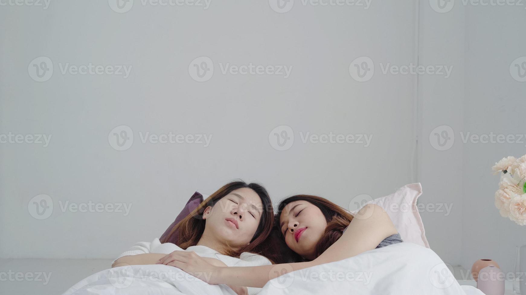 Asian Lesbian lgbtq women couple wake up at home. Young Asia lover female happy relax rest together after sleep all night on bed while lying on bed in bedroom at home in the morning concept. photo