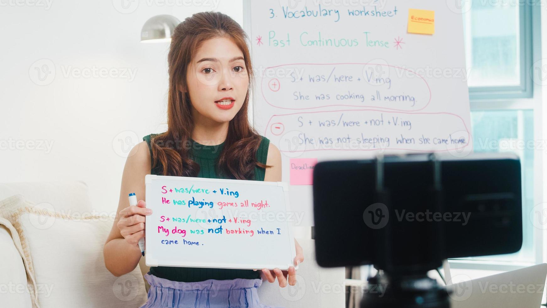 videoconferencia de una joven profesora de inglés de asia llamando a una conversación de teléfono inteligente por cámara web para aprender a enseñar en el chat en línea en casa. educación remota, distanciamiento social, cuarentena para la prevención del virus de la corona. foto