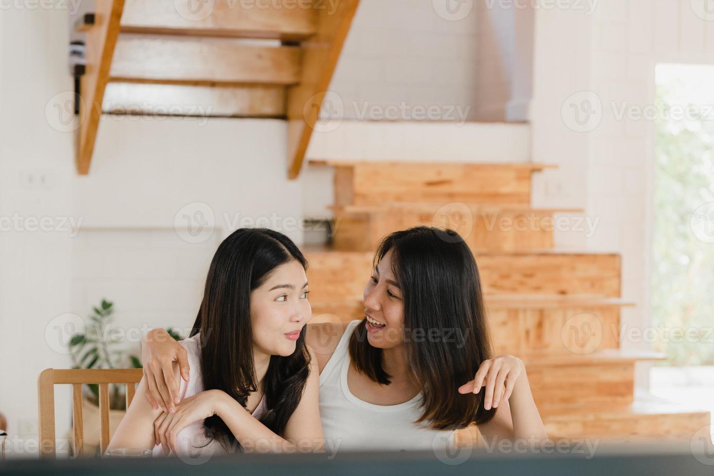 Asian Lesbian lgbtq women couple have breakfast at home, Young Asia lover girls happy watching TV while drink juice, corn flakes cereal and milk in bowl on table in kitchen in the morning concept. photo