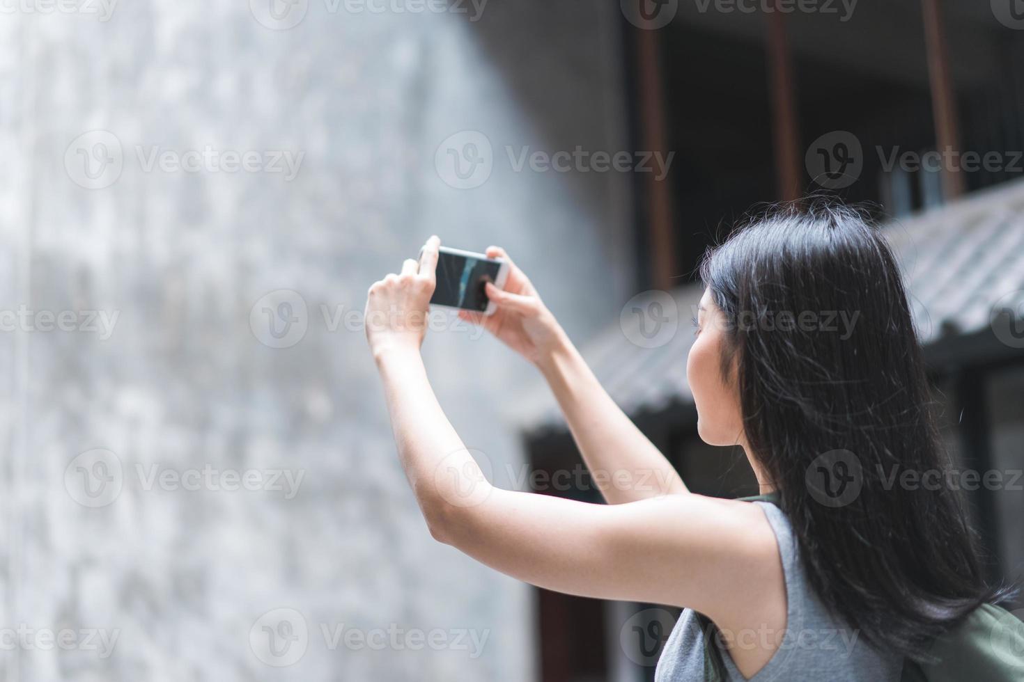 Traveler Asian woman using mobile phone for take a picture while spending holiday trip at Beijing, China, female enjoy journey at amazing landmark in city. Lifestyle women travel in city concept. photo