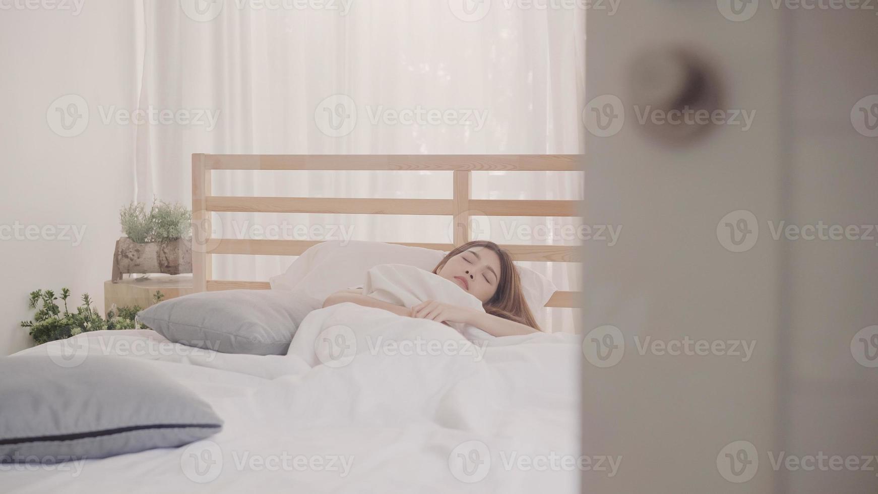 Asian woman dreaming while sleeping on bed in bedroom, Beautiful japanese female using relax time lying on bed at home. Lifestyle women using relax time at home concept. photo