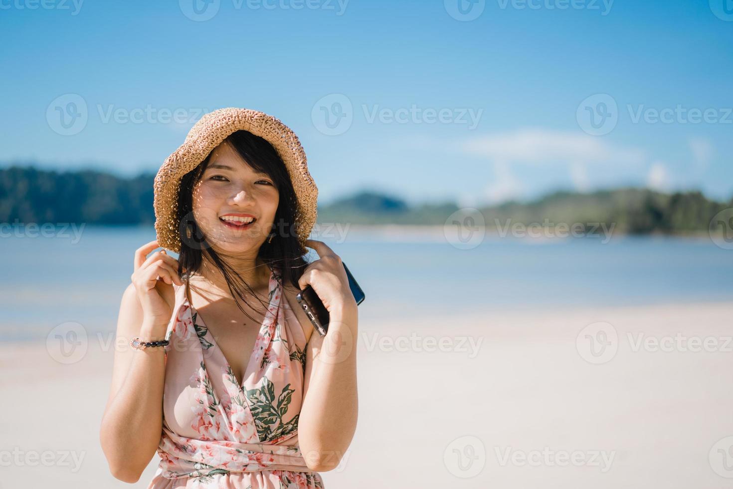 hermosa joven asiática feliz relajarse caminando en la playa cerca del mar. las mujeres de estilo de vida viajan en concepto de playa. foto