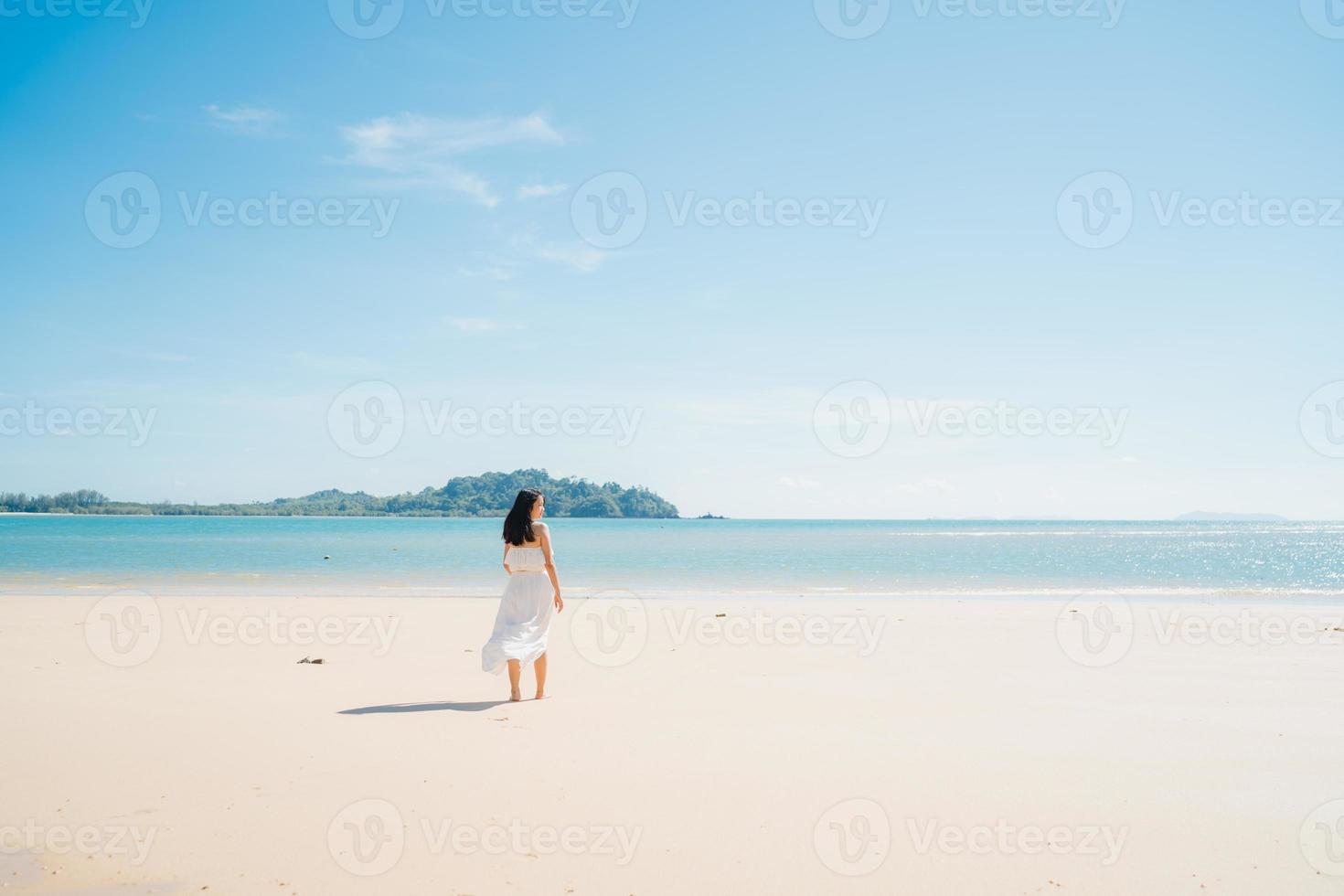 Beautiful young Asian woman happy relax walking on beach near sea. Lifestyle women travel on beach concept. photo