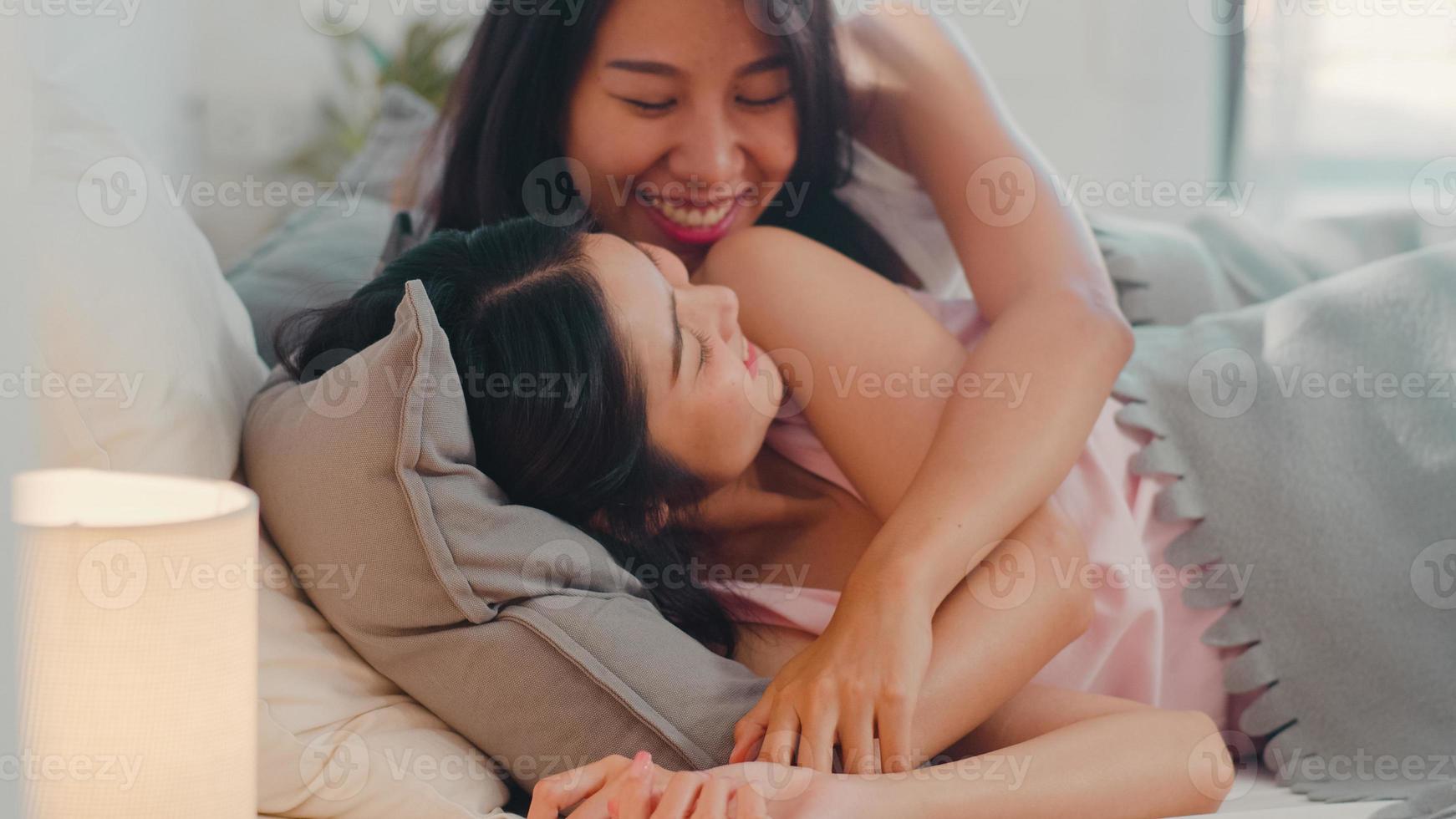 Asian Lesbian lgbtq women couple wake up at home. Young Asia lover female happy relax rest together after sleep all night on bed while lying on bed in bedroom at home in the morning concept. photo