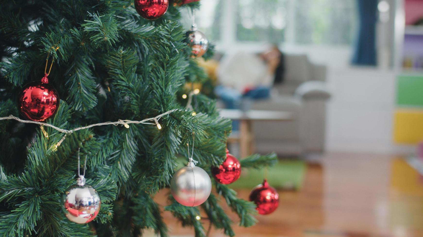cerca del árbol de navidad y adornos navideños en la sala de estar en casa. foto